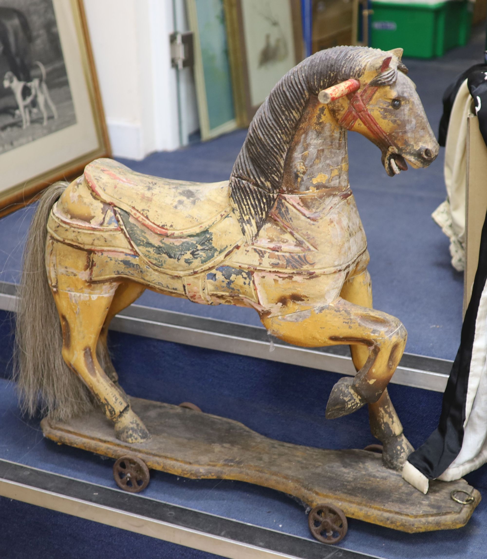 A painted carved wood Merry-go-round horse now in a wheeled base, height 80cm